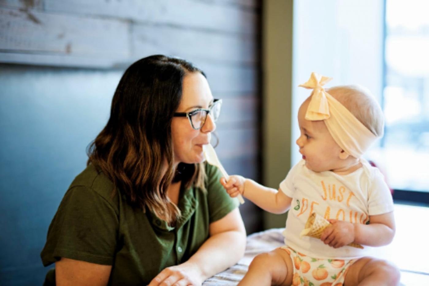 Baby giving mom a bit of ice cream